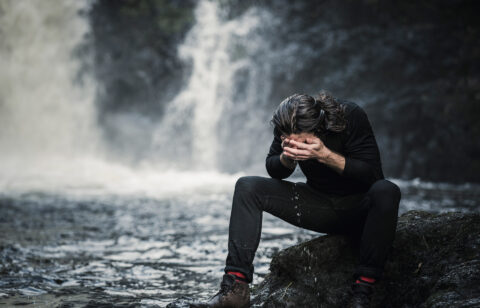 a-man-sitting-washing-his-face-in-a-mountain-strea-2026-01-09-09-55-05-utc