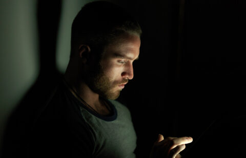 young-man-using-smartphone-at-night-face-illumina-2026-01-09-10-58-29-utc
